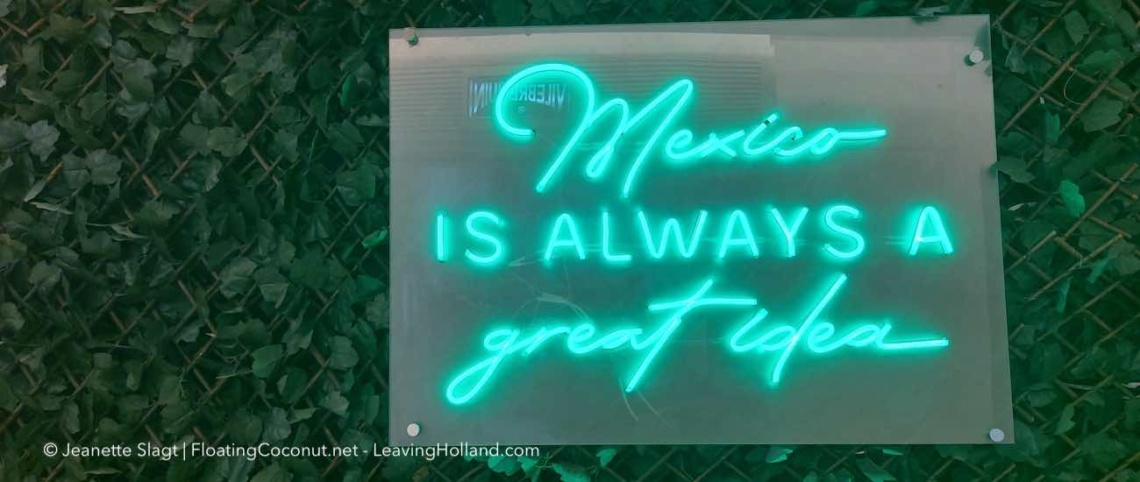 groene neonverlichting "Mexico is always a great idea", tegen een groene kunstbladeren wand.