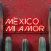 roden muur met de tekst: Mexico mi amor in neon letters en daaronder een rij groene cactussen